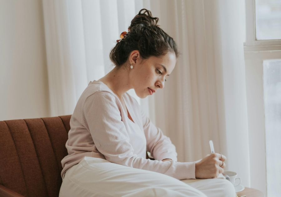 woman journaling in her living room